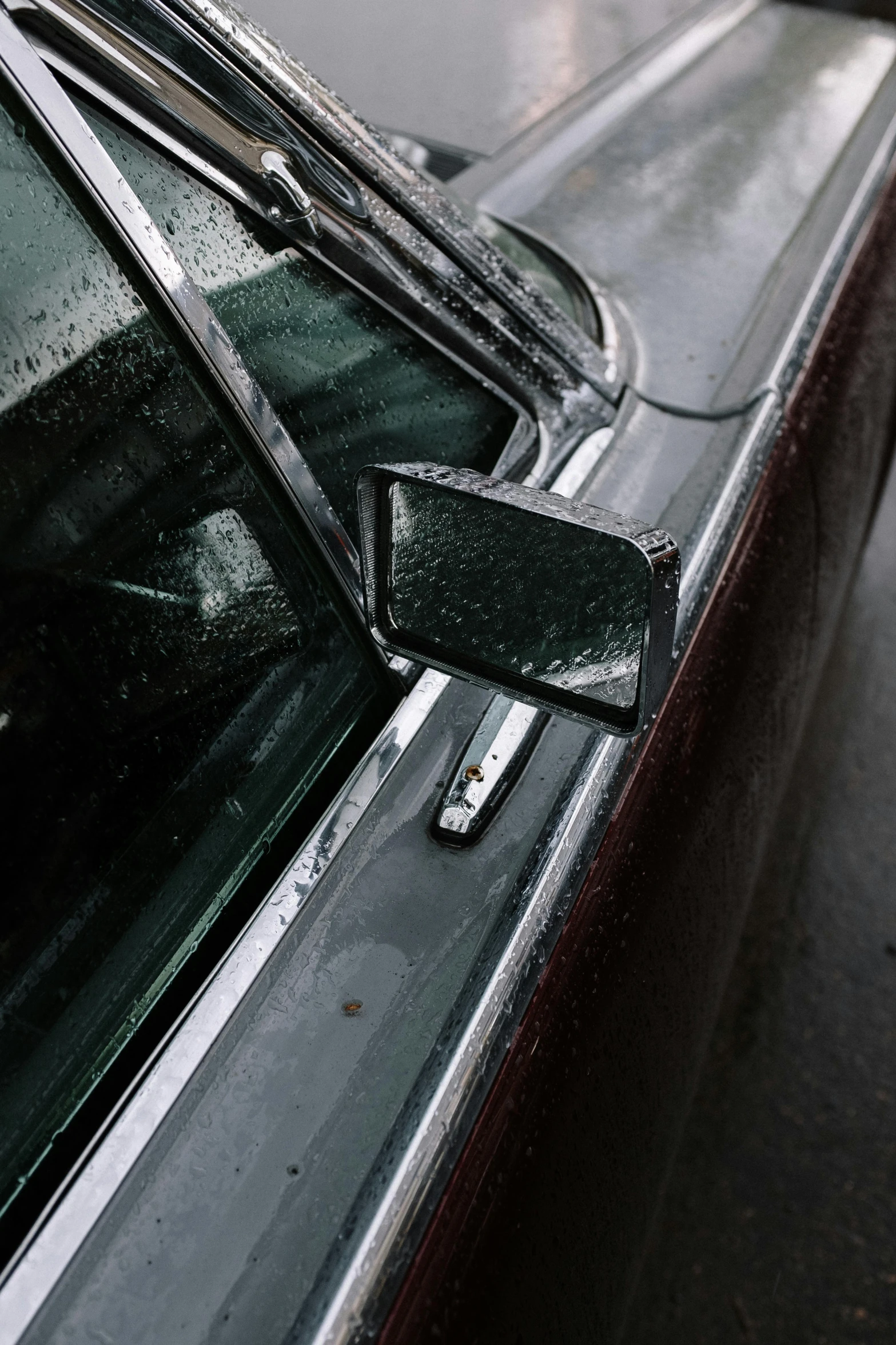 a dog sitting in the driver's seat of a car, an album cover, by Sven Erixson, unsplash, photorealism, wet metal reflections, 1 9 7 0 s car window closeup, rain aesthetic, broken mirror