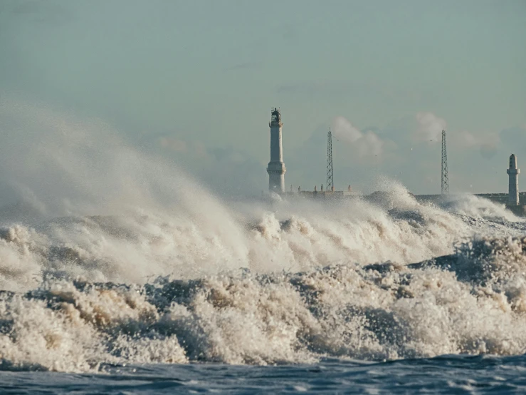 a large body of water with a lighthouse in the background, by Adam Marczyński, pexels contest winner, big wave and foam, turbines, chicago, tan