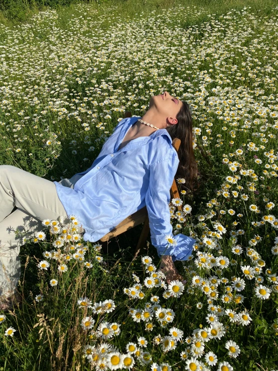 a woman laying on a bench in a field of daisies, happening, wearing a linen shirt, sky blue, sandro botticelli style, wearing a light blue shirt