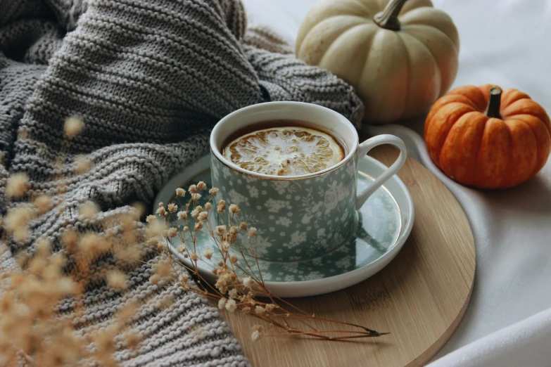 a cup of coffee sitting on top of a wooden tray, by Emma Andijewska, trending on pexels, romanticism, pumpkin, covered with blanket, soup, teal aesthetic