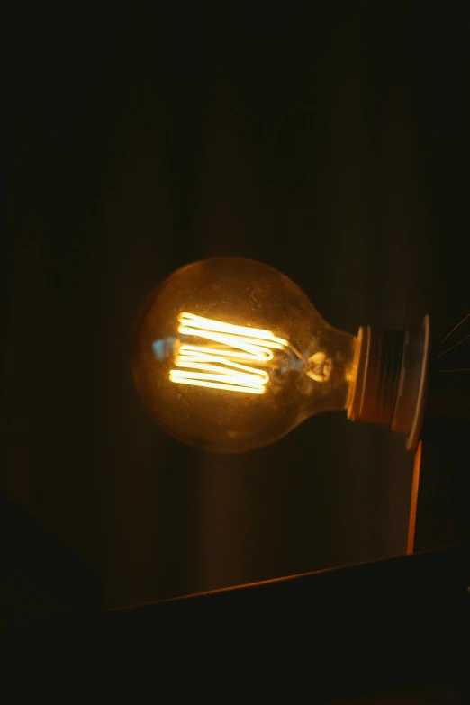 a light bulb sitting on top of a wooden table