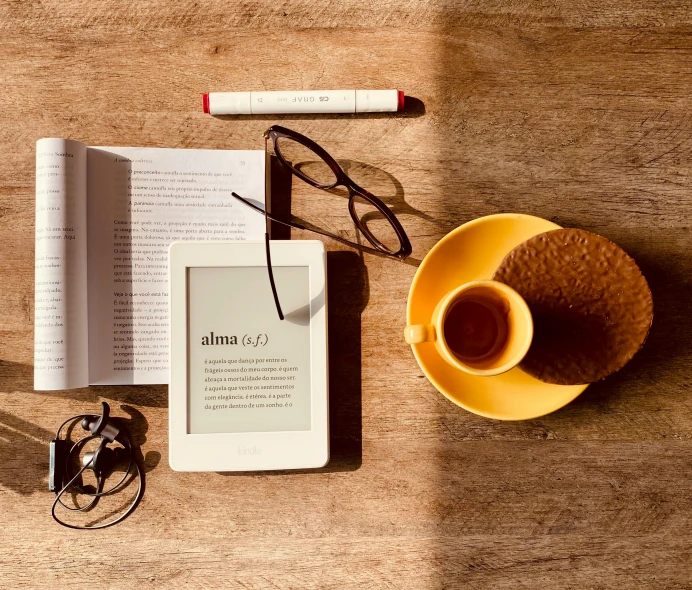 an open book sitting on top of a wooden table next to a cup of coffee, by Carey Morris, pexels contest winner, using a magical tablet, on a yellow canva, alexa mini, dwell