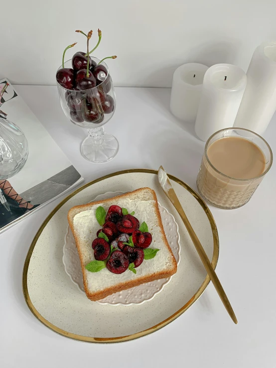 a white plate topped with a piece of bread next to a cup of coffee, a still life, by Eizan Kikukawa, cherries, 🎀 🧟 🍓 🧚, on a candle holder, product introduction photo