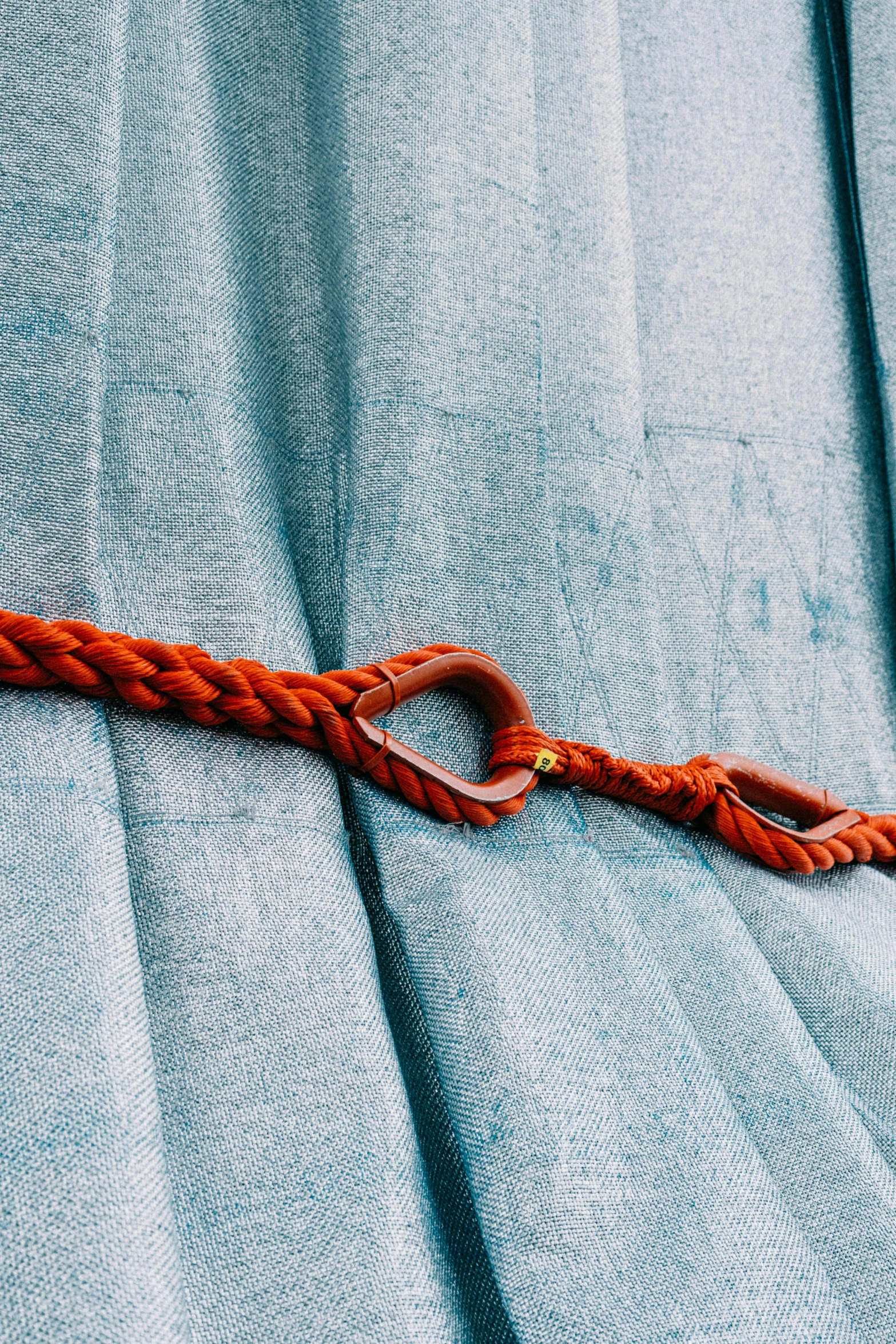 a close up of a rope on a curtain, an album cover, unsplash, burnt sienna and cerulean blue, belt, harnesses, ultrafine detail