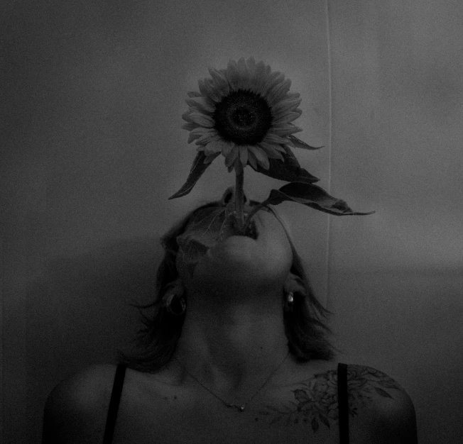 a woman with a sunflower on her head, a black and white photo, unsplash contest winner, aestheticism, flowers growing out of his body, emily rajtkowski, album cover, about to consume you