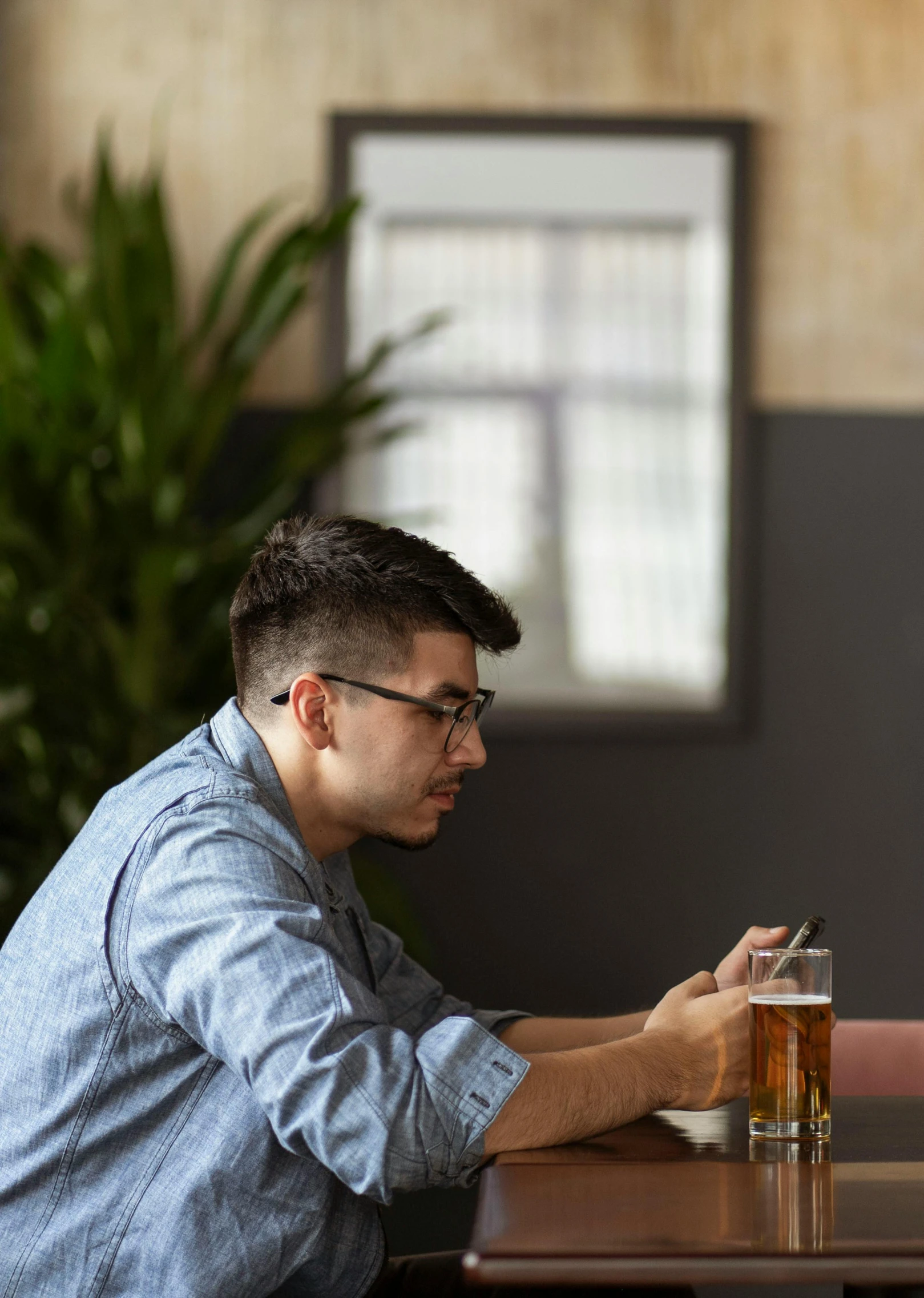 two men sitting at a table looking at a cell phone, pexels, realism, man drinking beer, jewish young man with glasses, a single, panels