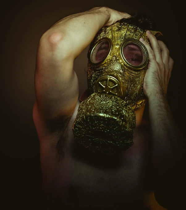 a man with a gas mask covering his face, an album cover, inspired by Elsa Bleda, pexels contest winner, nuclear art, gold bodypaint, buff man, cgsociety 8 k, kris kuksi