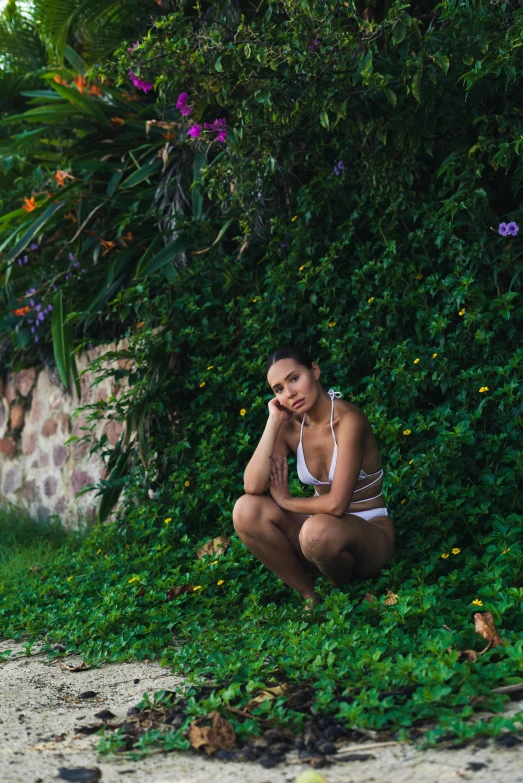 a woman sitting on the ground talking on a cell phone, a picture, inspired by Elsa Bleda, pexels contest winner, renaissance, lush greenery, jamaica, looking seductive, resort