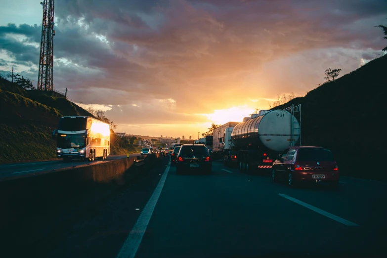 a number of cars on a road with a sunset in the background, by Niko Henrichon, pexels contest winner, truck, traffic accident, 🚿🗝📝