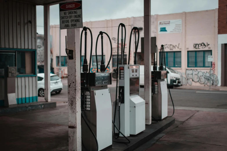 a row of gas pumps at a gas station, pexels contest winner, les automatistes, thick cables on ground, dystopian feel, instagram photo, 4 0 9 6