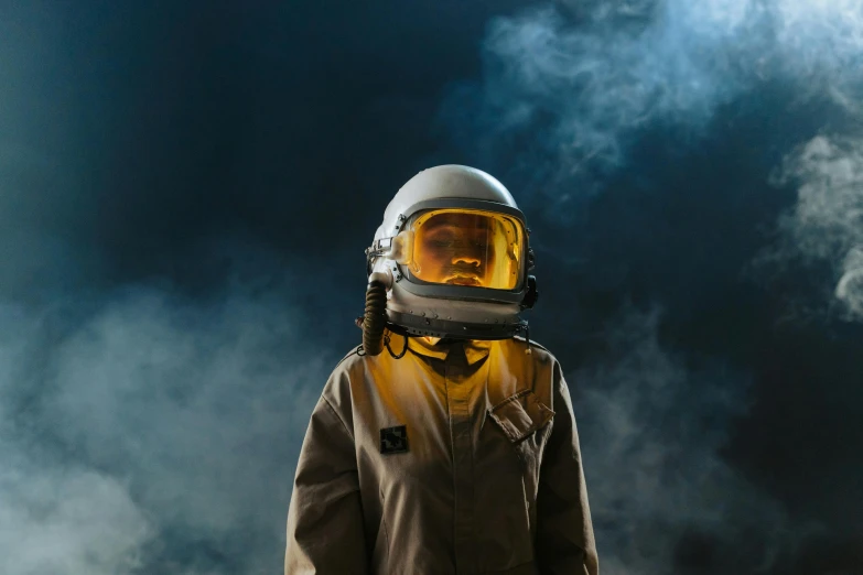a person wearing a helmet and holding a skateboard, pexels contest winner, afrofuturism, clothed in space suit, smokey atmosphere, vintage pilot clothing, portrait of mad lady scientist