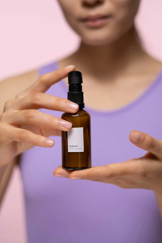 a woman holding a bottle of essential oil, by Sam Black, purism, detailed product image, hands shielding face, mini model, kami