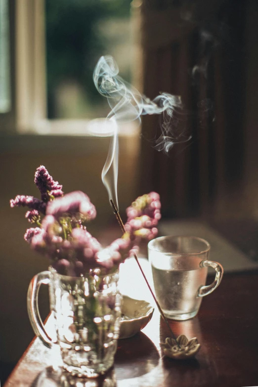 a vase of flowers sitting on top of a wooden table, incense smoke fills the air, secret tea society, cosy