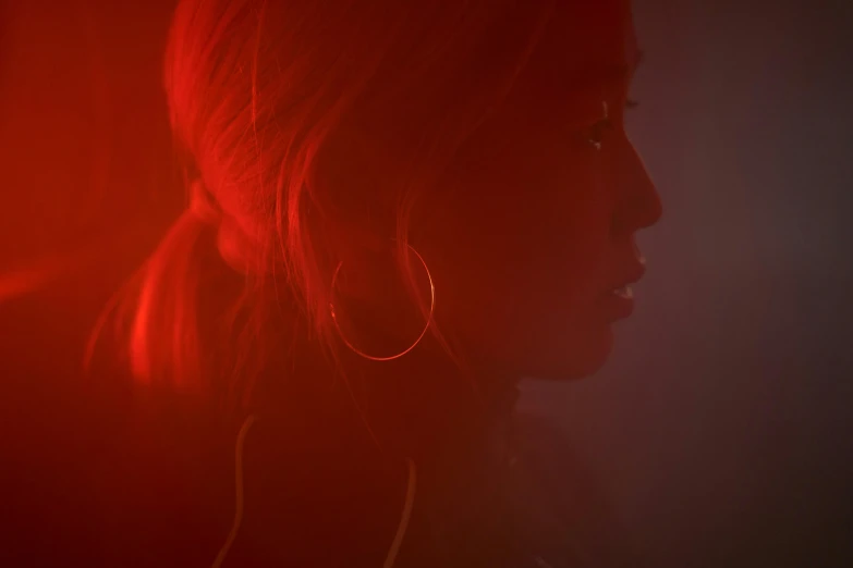 a woman standing in front of a red light, an album cover, inspired by Elsa Bleda, pexels, realism, a young asian woman, studio backlight, portrait of maci holloway, still from a music video