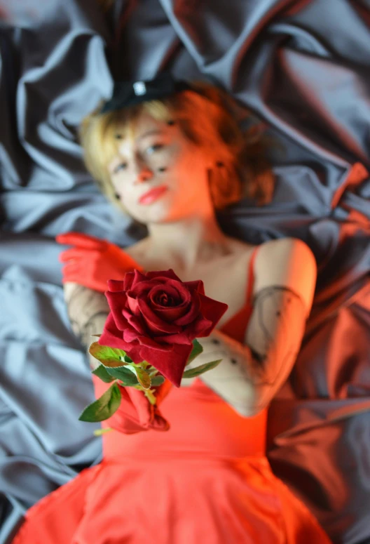 a woman laying on a bed with a rose in her hand, an album cover, inspired by Elsa Bleda, flickr, asuka langley, singularity sculpted �ー etsy, lil peep, cosplay photo