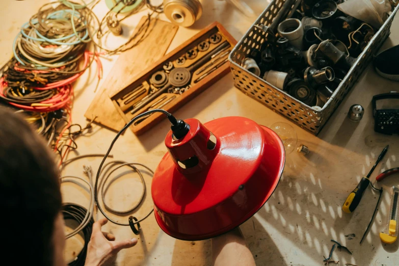 a red fire hydrant sitting on top of a table, by Matthias Stom, trending on pexels, assemblage, cables hanging from ceiling, morrocan lamp, in a workshop, overhead view