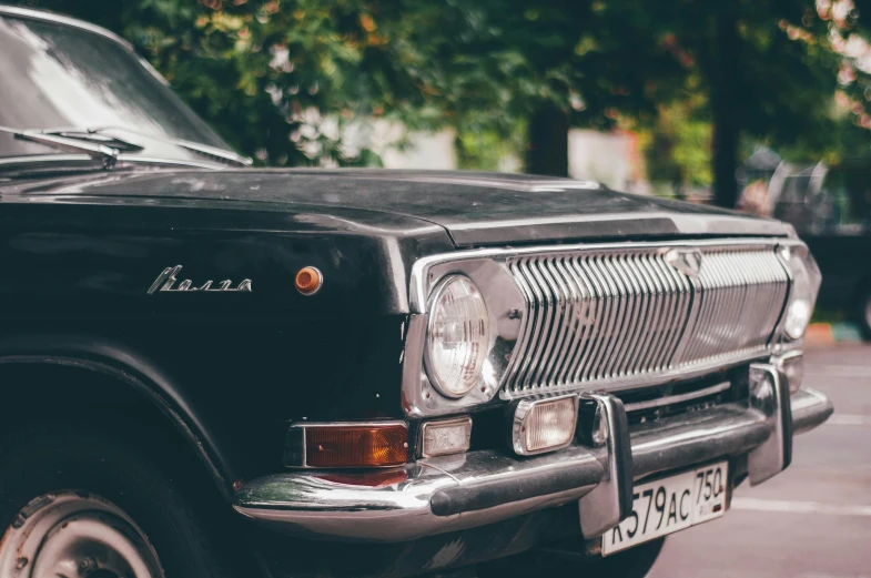 a black car parked in a parking lot, an album cover, by Adam Marczyński, pexels contest winner, russian lada car, local close up, vintage - w 1 0 2 4, bumps