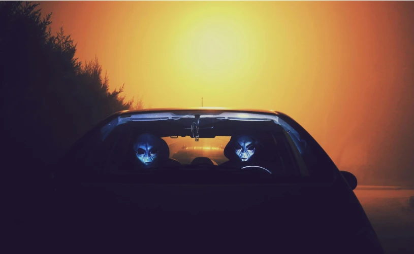 a couple of people sitting in the back of a car, an album cover, inspired by Elsa Bleda, conceptual art, alien skulls, glowing orange eyes, profile image, instagram photo