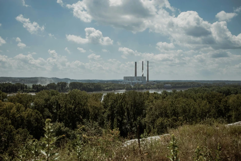 a view of a power plant from the top of a hill, an album cover, by Dan Frazier, unsplash, old american midwest, river in the background, overgrown environment, 2 0 2 2 photo