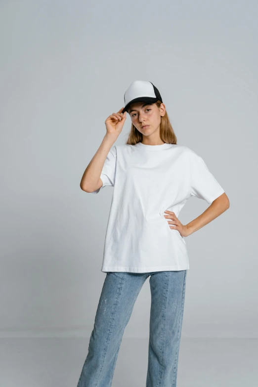 a woman wearing a white t - shirt and jeans, trending on unsplash, realism, baggy clothing and hat, plain background, trending on r/streetwear, 5 0 0 px models