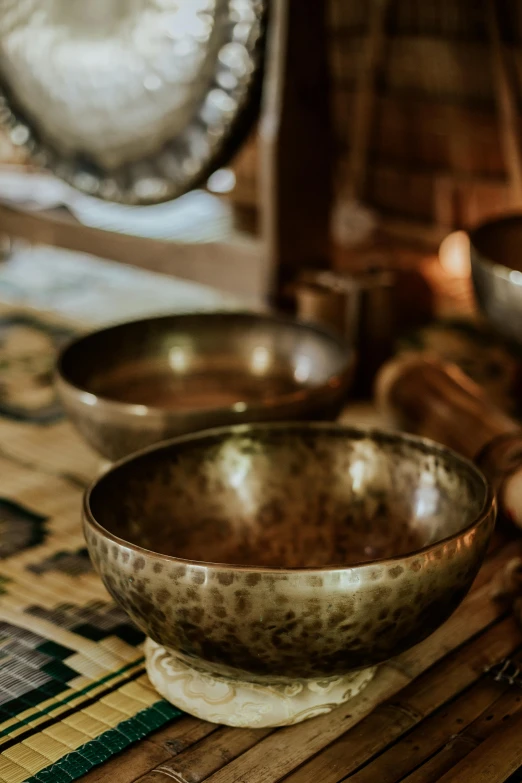 a group of bowls sitting on top of a wooden table, an instrument