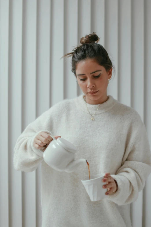 a woman pouring a cup of coffee into a mug, by Grace Polit, wearing a white sweater, alex flores, gif, multiple stories