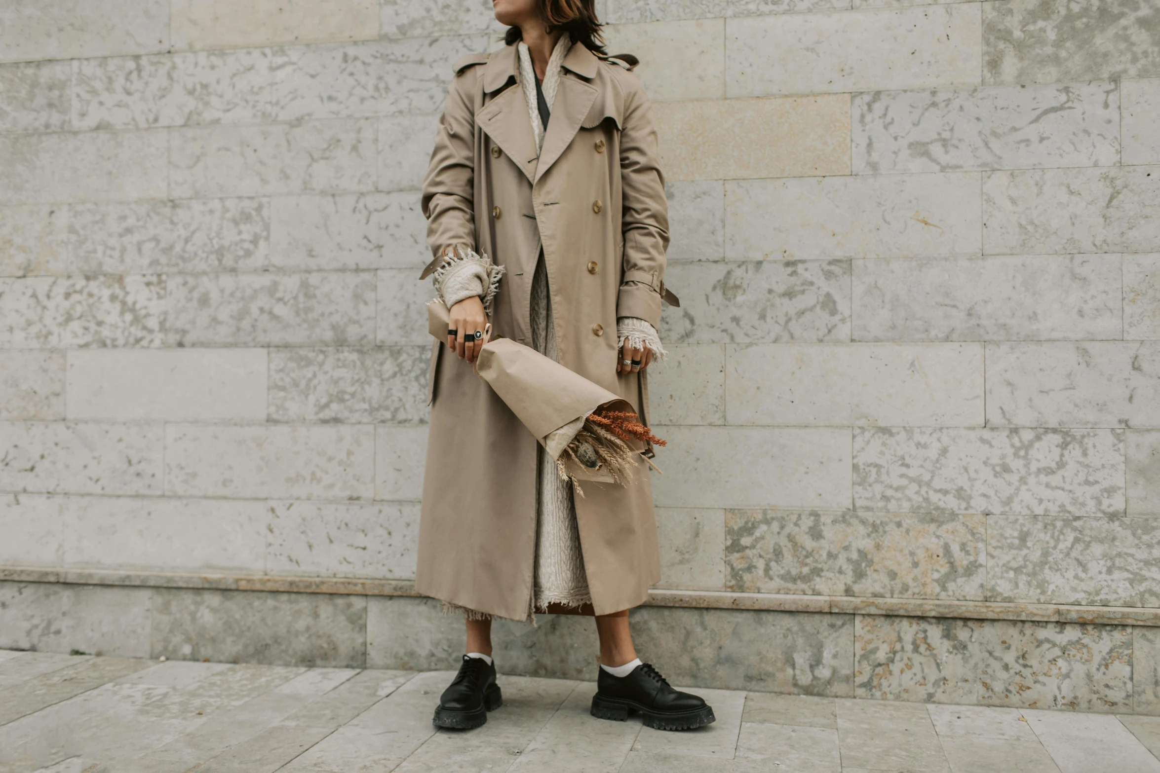 a woman in a trench coat holding an umbrella, trending on pexels, on the concrete ground, trench coat with many pockets, beige, offwhite