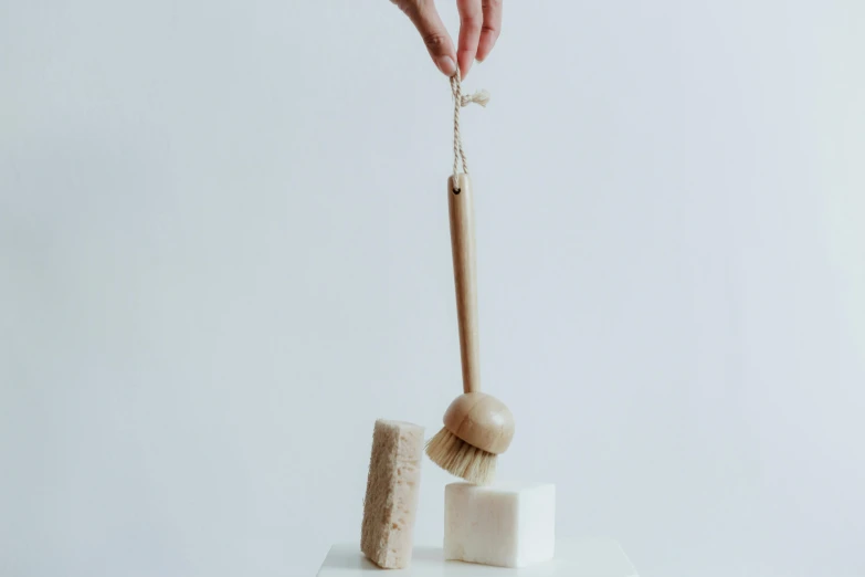 a close up of a person holding a brush, a marble sculpture, hanging rope, product shot, eco, cedar