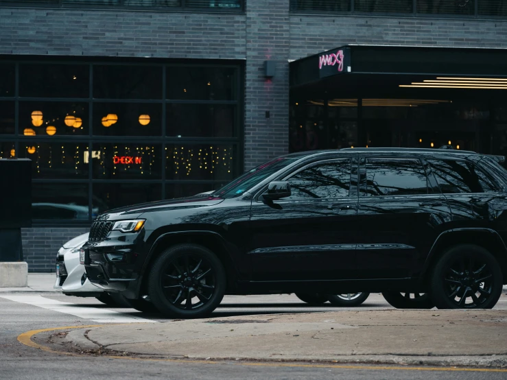 a black jeep parked in front of a building, by Adam Rex, pexels contest winner, modern chicago streets, right side profile, finely detailed car, casually dressed