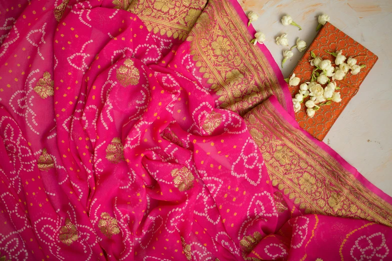 a pink sari sitting on top of a table, flatlay, vibrant patterns, thumbnail, golden detailing