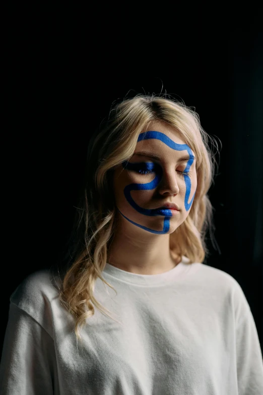 a woman with blue paint on her face, an album cover, trending on pexels, sydney sweeney, tribal paint, teenager, scribbled