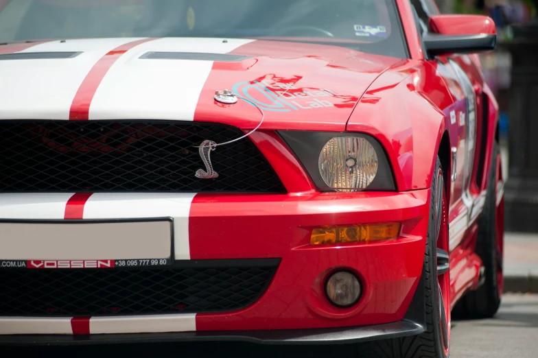 a red and white mustang parked on the side of the road, pexels contest winner, red facial stripe, on a street race track, close - up photo, taken in the late 2010s