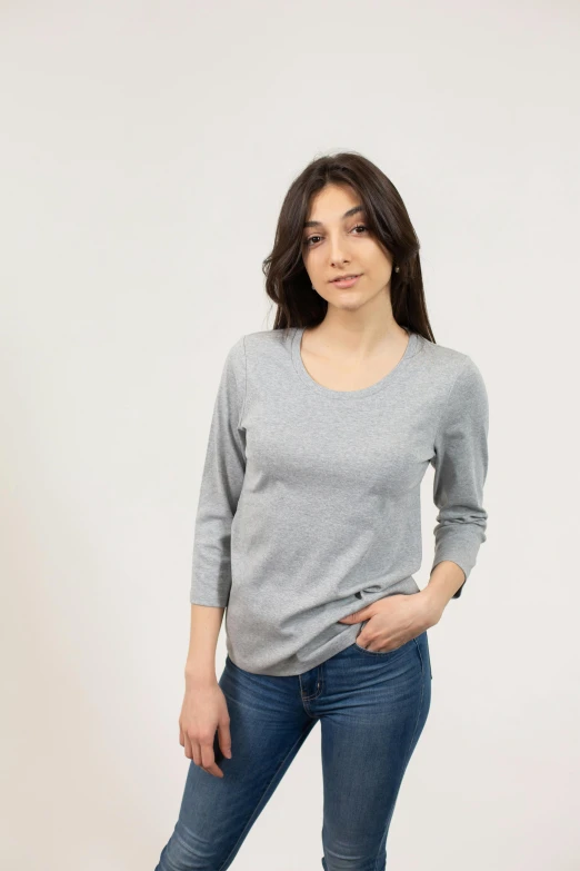 a woman standing with her hands in her pockets, by Matthias Stom, pexels contest winner, figuration libre, grey sweater, ecommerce photograph, wearing a cute top, official government photo