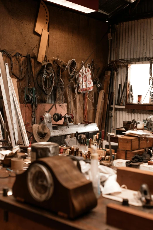 a room filled with lots of tools sitting on top of a wooden table, inside a barn, miscellaneous objects, rusty vehicles, lachlan bailey