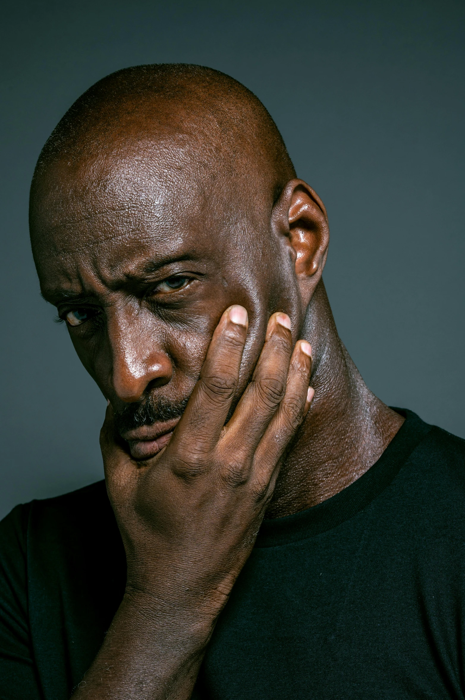 a man holding his hand to his face, inspired by Terrell James, lance reddick, scowl, michael jordan, medium shoot