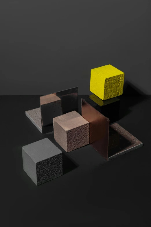 a group of cubes sitting on top of each other, inspired by Louise Nevelson, yellow charcoal, textured base ; product photos, a high angle shot, award-winning render