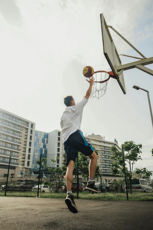 a man that is jumping in the air with a basketball, in the middle of the city, playing basketball, tournament, instagram post