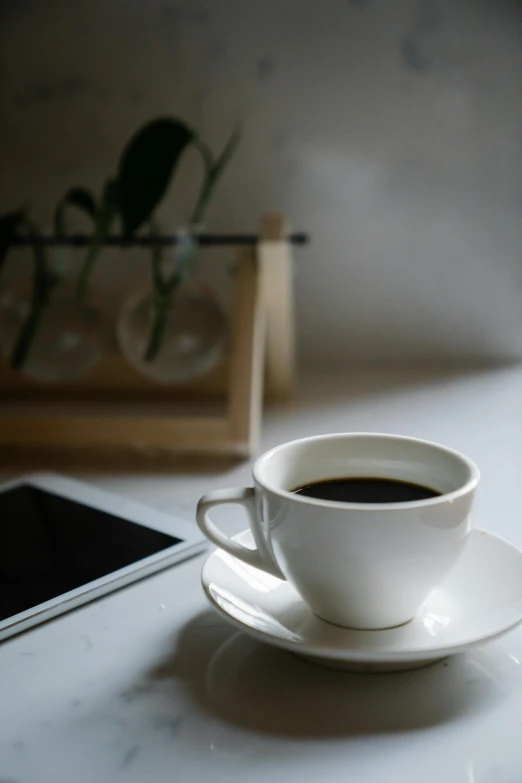 a cup of coffee and a cell phone on a table, curated collections, digital image, multiple stories, white