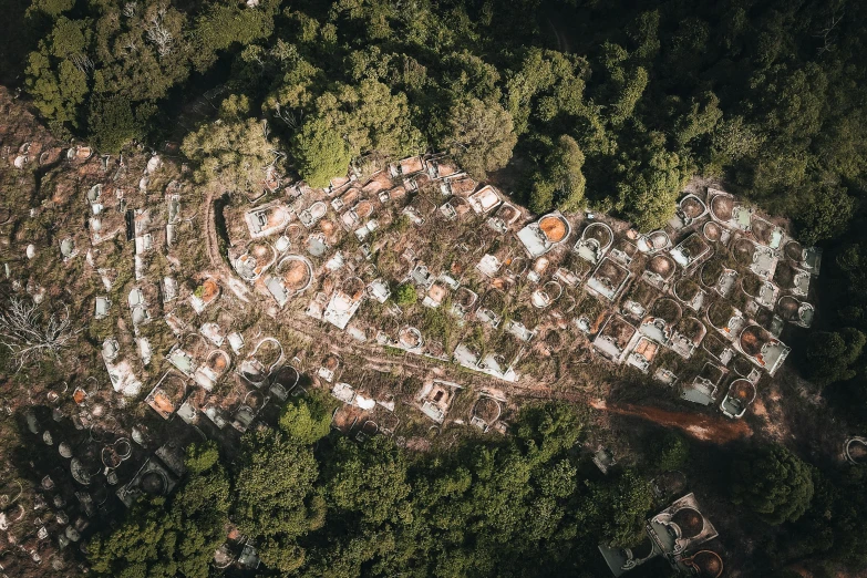 a bird's eye view of a city surrounded by trees, by Daniel Lieske, unsplash contest winner, auto-destructive art, big graveyard gravestones, favela, 2000s photo, burnt huts