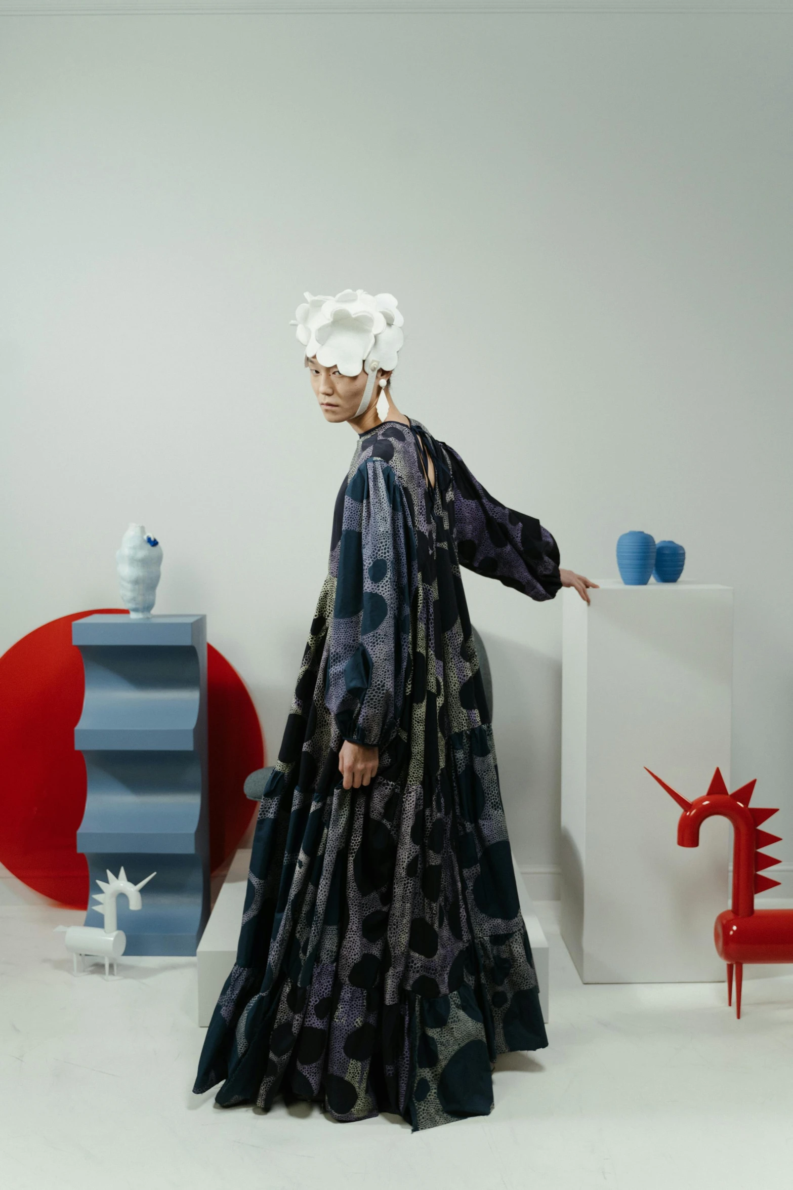 a woman in a long dress standing in a room, a surrealist sculpture, inspired by Gao Cen, maximalism, short blue haired woman, dragon-inspired cloth robes, ouchh and and innate studio, in front of white back drop