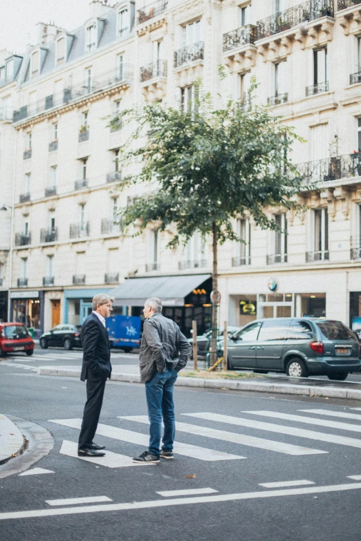 a couple of people that are standing in the street, trending on unsplash, paris school, business men, lush surroundings, lgbtq, in a square