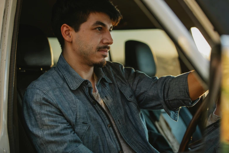 a man sitting in the driver's seat of a truck, trending on pexels, renaissance, nathan fielder, wearing double denim, avatar image, candid portrait photo