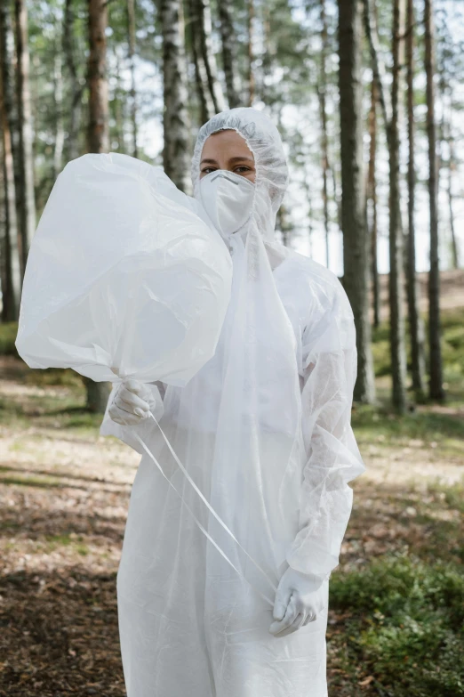 a woman in a white coverall standing in the woods, unsplash, plasticien, made of lab tissue, balloon, funeral veil, inspect in inventory image