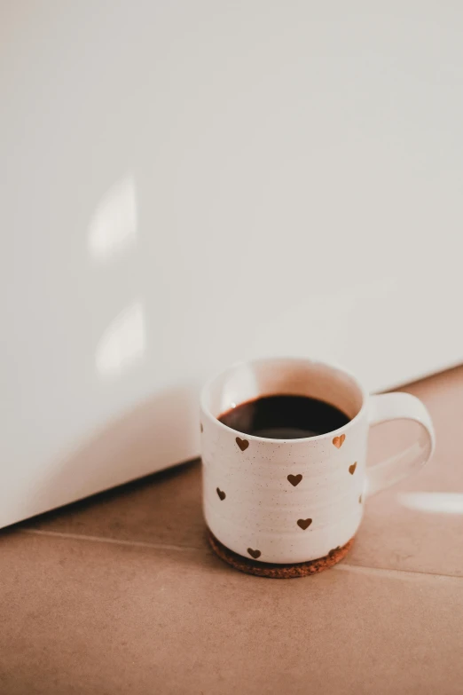 a cup of coffee sitting in front of a laptop, trending on unsplash, minimalism, heartbreak, high quality photo, low sun, sitting in an empty white room