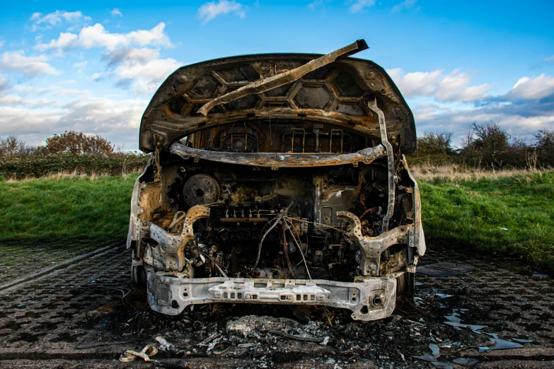 a burnt out car on the side of the road, unsplash, auto-destructive art, lpoty, eye level view, van, taken with canon 5d mk4