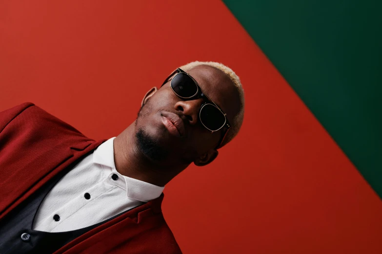 a man in a suit and sunglasses poses for a picture, inspired by Michael Ray Charles, trending on pexels, afrofuturism, red and green, one man is blond, studio photoshoot, deep colours. ”