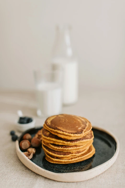 a stack of pancakes sitting on top of a plate, a still life, unsplash, detailed product image, pumpkin, milk puddles, background image