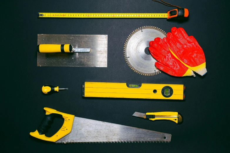 a variety of tools laid out on a table, a portrait, pexels, plasticien, black and yellow and red scheme, saws, circular, panel