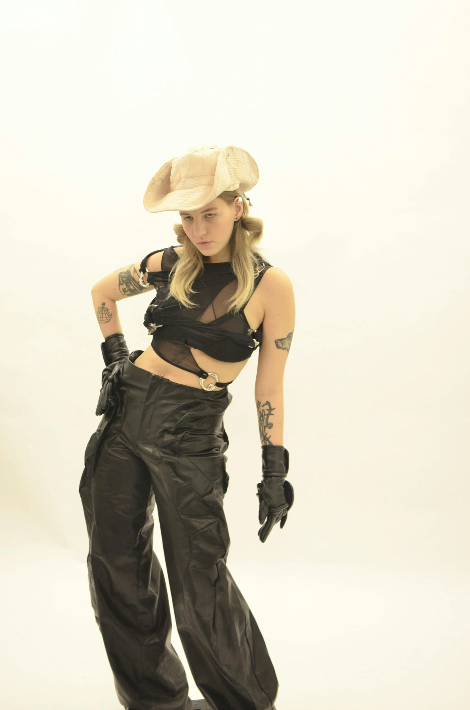 a woman that is standing on a skateboard, wearing a cowboy hat, photograph of a techwear woman, miley cyrus, black leather costume