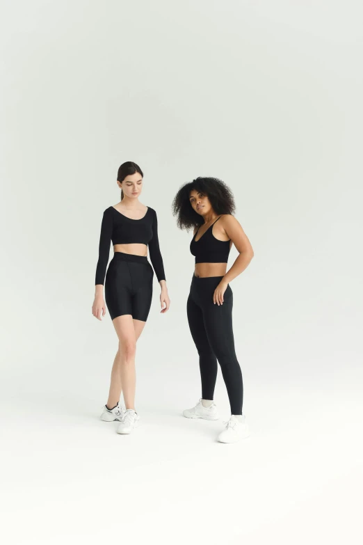 a couple of women standing next to each other, black spandex, wearing crop top, large thighs, off - white collection